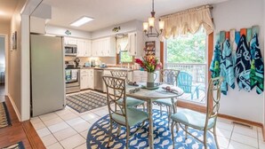 A kitchen with white cabinets, a dining table with chairs, a chandelier, and a window with curtains. - LakingitEz..3BR/2BA amazing sunsets & hot tub (Inman)