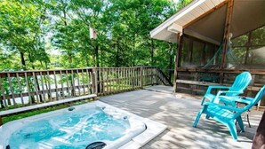 A wooden deck with a hot tub, two turquoise chairs, and a covered area with a hammock. - LakingitEz..3BR/2BA amazing sunsets & hot tub (Inman)