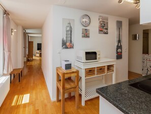Une cuisine moderne équipée d’un four à micro-ondes, de meubles en bois et d’une petite table.