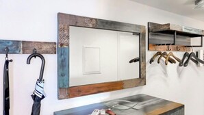 A bathroom with a wooden vanity, a mirror, and a towel rack. - Apartment Orya by Interhome (Interlaken)