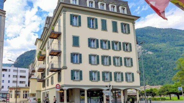 A multi-story hotel with a flat roof, multiple balconies, and a ground-level entrance. - Apartment Orya by Interhome (Interlaken)