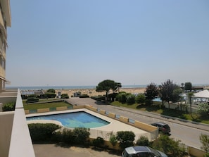 Zona de piscina con vista a la playa y al océano.