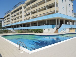 A modern hotel with a swimming pool, multiple balconies, and a covered outdoor area. - Flat in a Seafront Building With Swimming Pool (San Michele al Tagliamento)