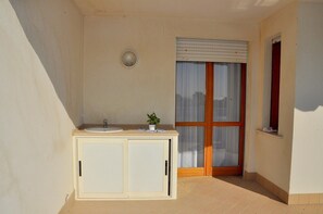 A small bathroom with a sink, cabinet, and a window with blinds. - Flat in a Seafront Building With Swimming Pool (San Michele al Tagliamento)