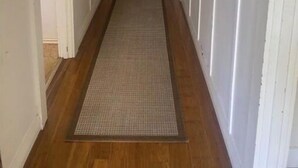 A long, narrow hallway with wooden floors and white walls. - Golden street cottage

 (West Wyalong)
