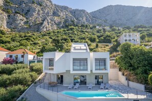 A modern two-story house with a swimming pool, surrounded by lush greenery and mountains. - Villa Fenella - Three Bedroom Villa, Sleeps 6 (Omis)