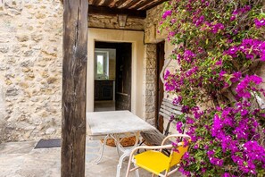 Un bâtiment en pierre avec un intérieur rustique, une table blanche et une chaise jaune.
