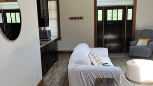 A bedroom with a bed, bedside table, and a large mirror.
