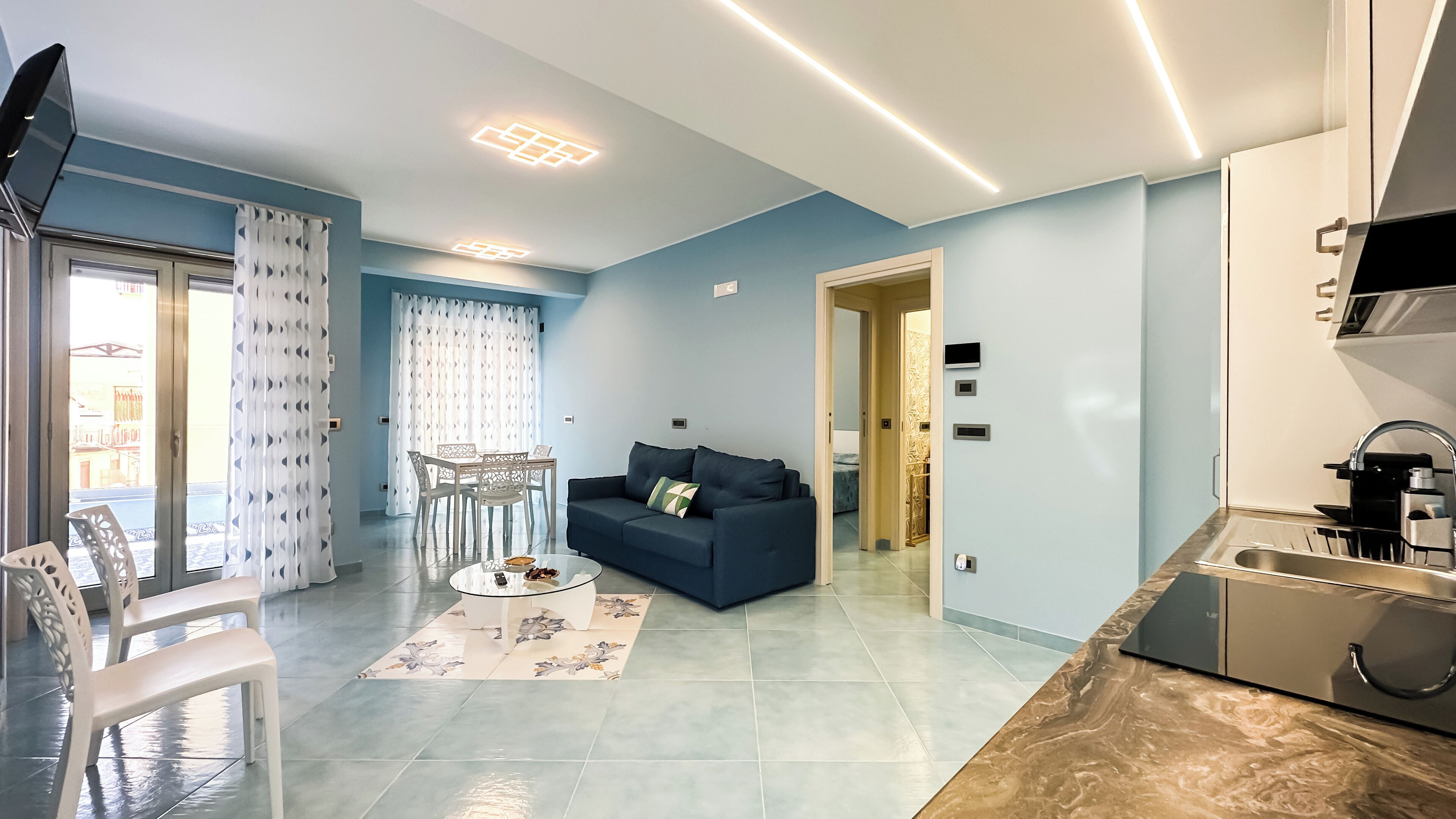 A modern apartment with a living room, dining area, and kitchen.