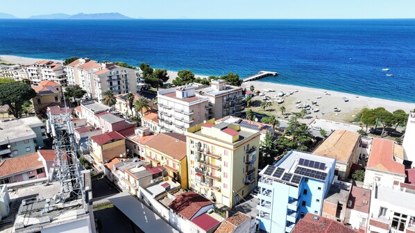 A coastal town with buildings, a beach, and boats.