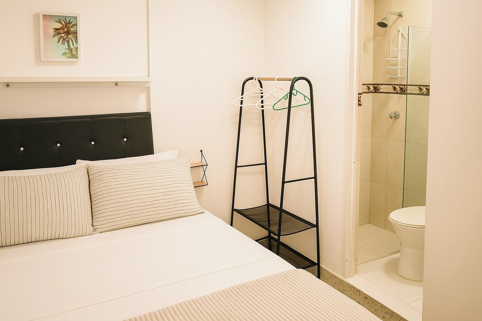 Un dormitorio con cama, una estantería metálica negra y un baño con ducha y retrete.