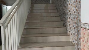 Una escalera con barandillas blancas y paredes de azulejos.