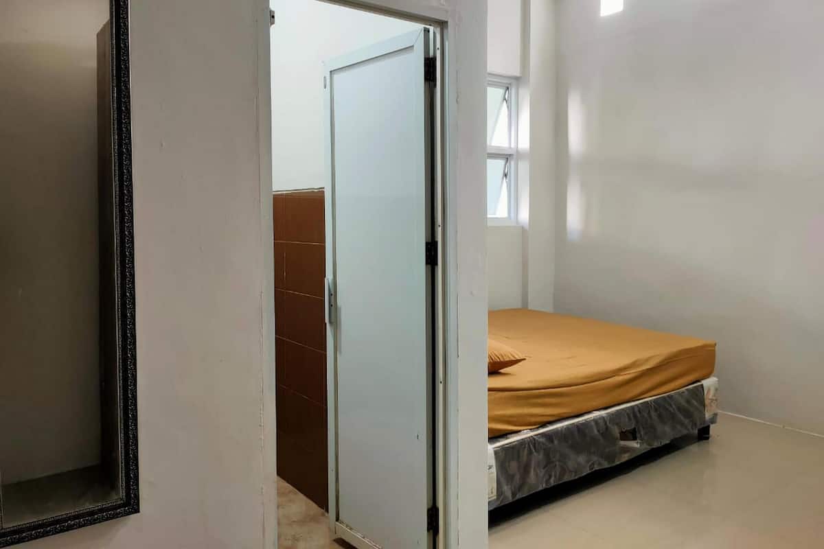 Een slaapkamer met een bed, een deur en een raam.