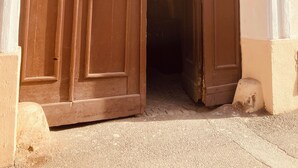 Une grande porte en bois à arc surmontée d’une enseigne.