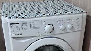 Eine weiße Indesit Waschmaschine mit Bedienfeld, einer Drehscheibe und einem Aufkleber, der eine 10-Jahres-Garantie anzeigt.