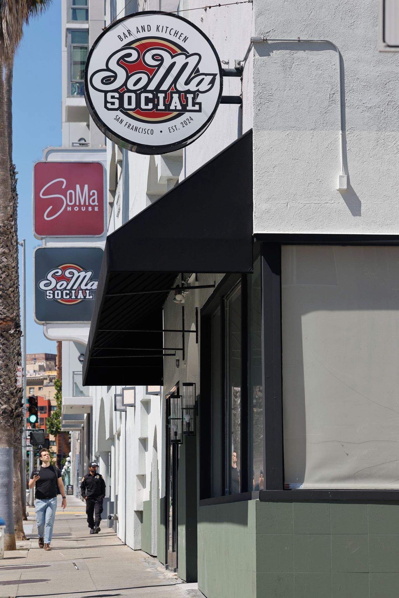 A building with a 'SoMa SOCIAL' sign, a 'SoMa HOUSE' sign, and a 'SoMa SOCIAL' sign with a leaf logo.