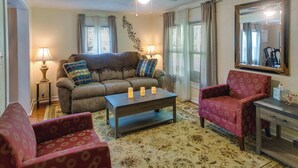 A living room with a sofa, armchairs, a coffee table, and a ceiling fan. - Waycross Vacation Rental w/ Private Backyard! (Waycross)