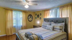A bedroom with a bed, a ceiling fan, and curtains. - Waycross Vacation Rental w/ Private Backyard! (Waycross)