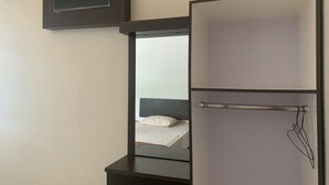 Une chambre d’hôtel moderne, équipée d’un lit, d’un petit bureau et d’un miroir.