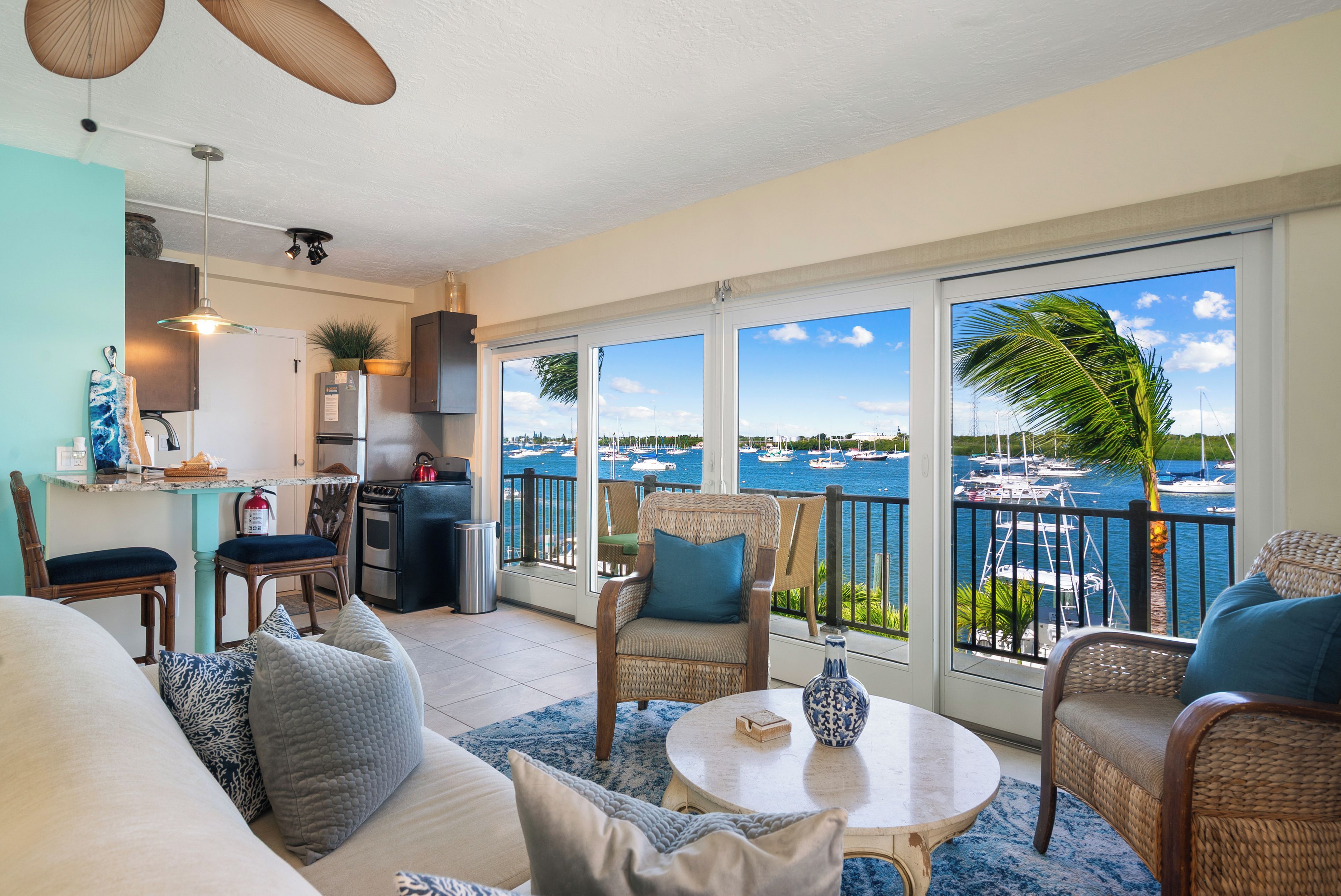 A spacious living area with a view of the marina, a kitchen with modern appliances, and comfortable seating.