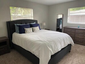 Cozy retreat with a large bed, dresser, and mirror.