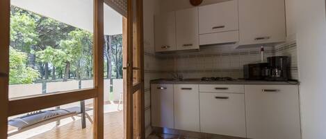 A kitchen with white cabinets, a tiled backsplash, and a coffee maker on the counter.