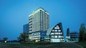 Um hotel moderno com uma torre imponente e um edifício curvo.