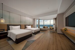 A modern hotel room with two beds, a seating area, a TV, and a large window offering a view. - Holiday Inn Chengdu East by IHG (Chengdu)