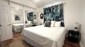 A bedroom with a large bed, a smaller bed, and a walk-in closet. - 1 Minute Walk to Ocean-Charming Downtown Beachside Home with Mother-In-Law Suite (Cocoa Beach)