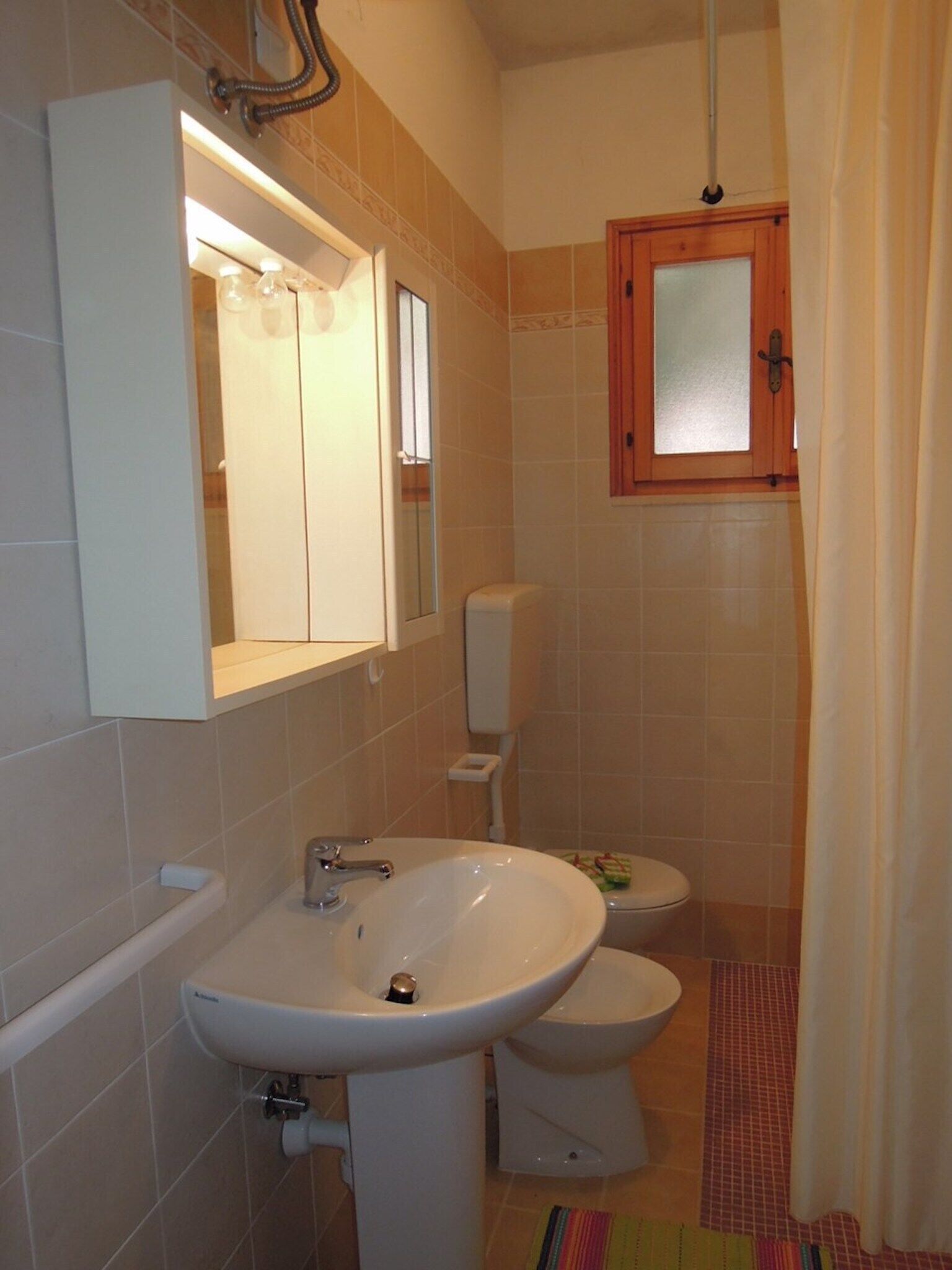 A bathroom with a white sink, a toilet, and a shower area.