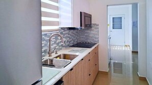 A modern kitchen with a stainless steel refrigerator, a microwave, and a tiled backsplash. - My Escape Dreamy Luxury Home in Bayamón, P.R. (DAVILA BAYAMON PR)