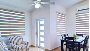 A modern living room with a sofa, a dining table with chairs, and a ceiling fan. - My Escape Dreamy Luxury Home in Bayamón, P.R. (DAVILA BAYAMON PR)