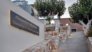 Una escalera de piedra que lleva a un edificio con letreros que dicen 'Alexandra's Mansion' y 'Alexinia's House'.