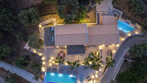 Vista aérea de una propiedad con piscina, zona de estar exterior y porche cubierto.