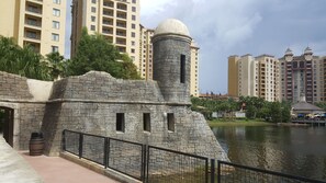 Une structure en pierre dotée d’un dôme et d’une tour cylindrique, entourée d’un plan d’eau et, en arrière-plan, de bâtiments modernes de grande hauteur.
