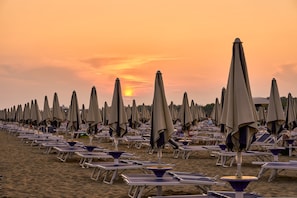 Relax on the beach with comfortable sun loungers and umbrellas.