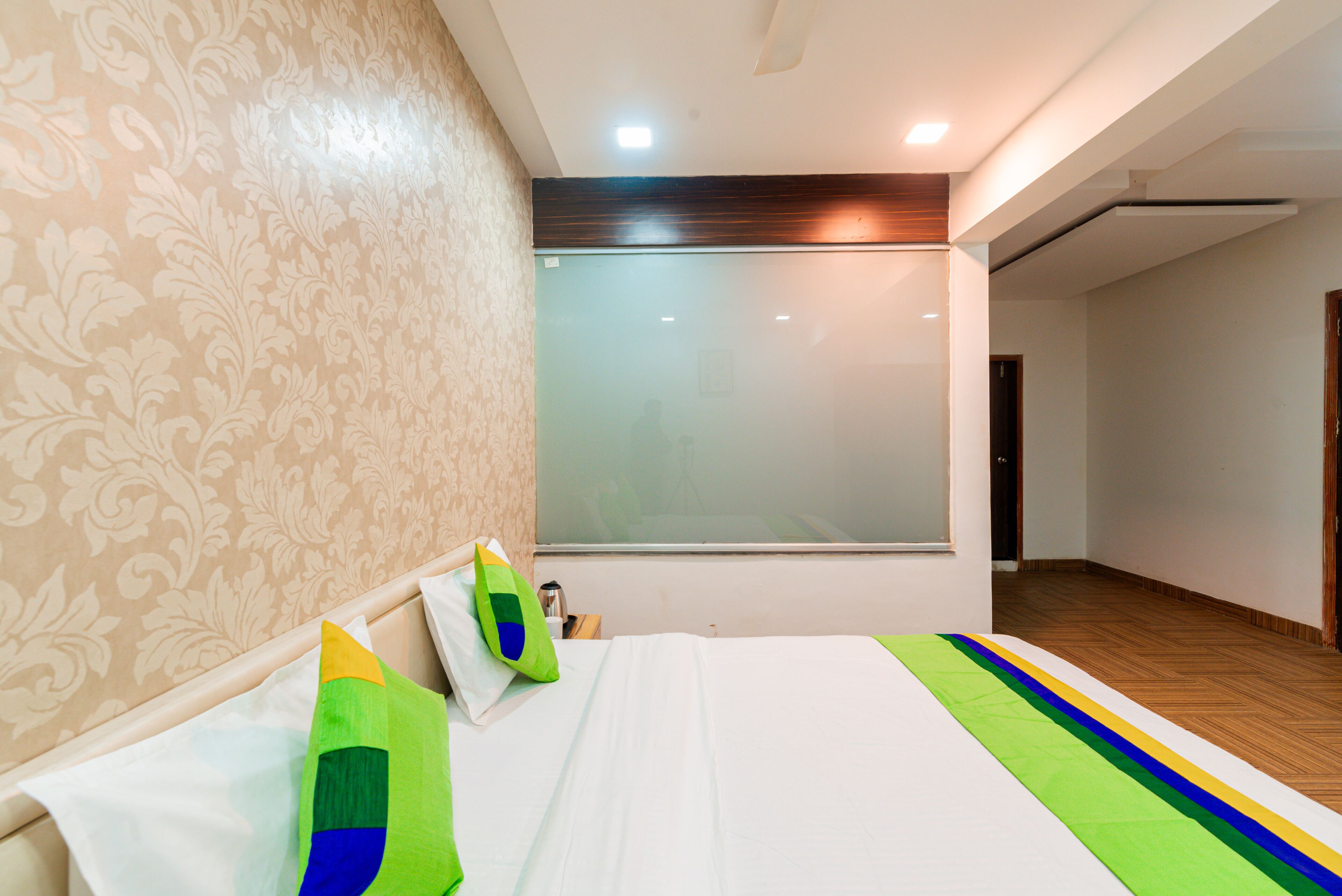 Une chambre d’hôtel avec un grand lit, une fenêtre et un plancher en bois.