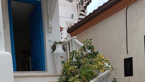 A white building with a blue door, white railing, and steps leading to a balcony. - Double Room, air Conditioning, Bathroom, (Tropea)