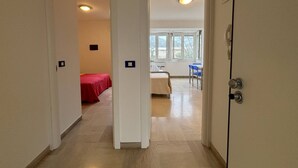Une chambre d’hôtel avec un lit, un bureau et une chaise. Il y a une fenêtre donnant sur l’extérieur.
