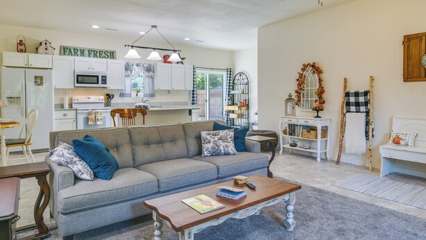 A living room with a grey sofa, a wooden coffee table, and a kitchen in the background. - Charming Gravois Mills Escape w/ Private Backyard! (Gravois Mills)