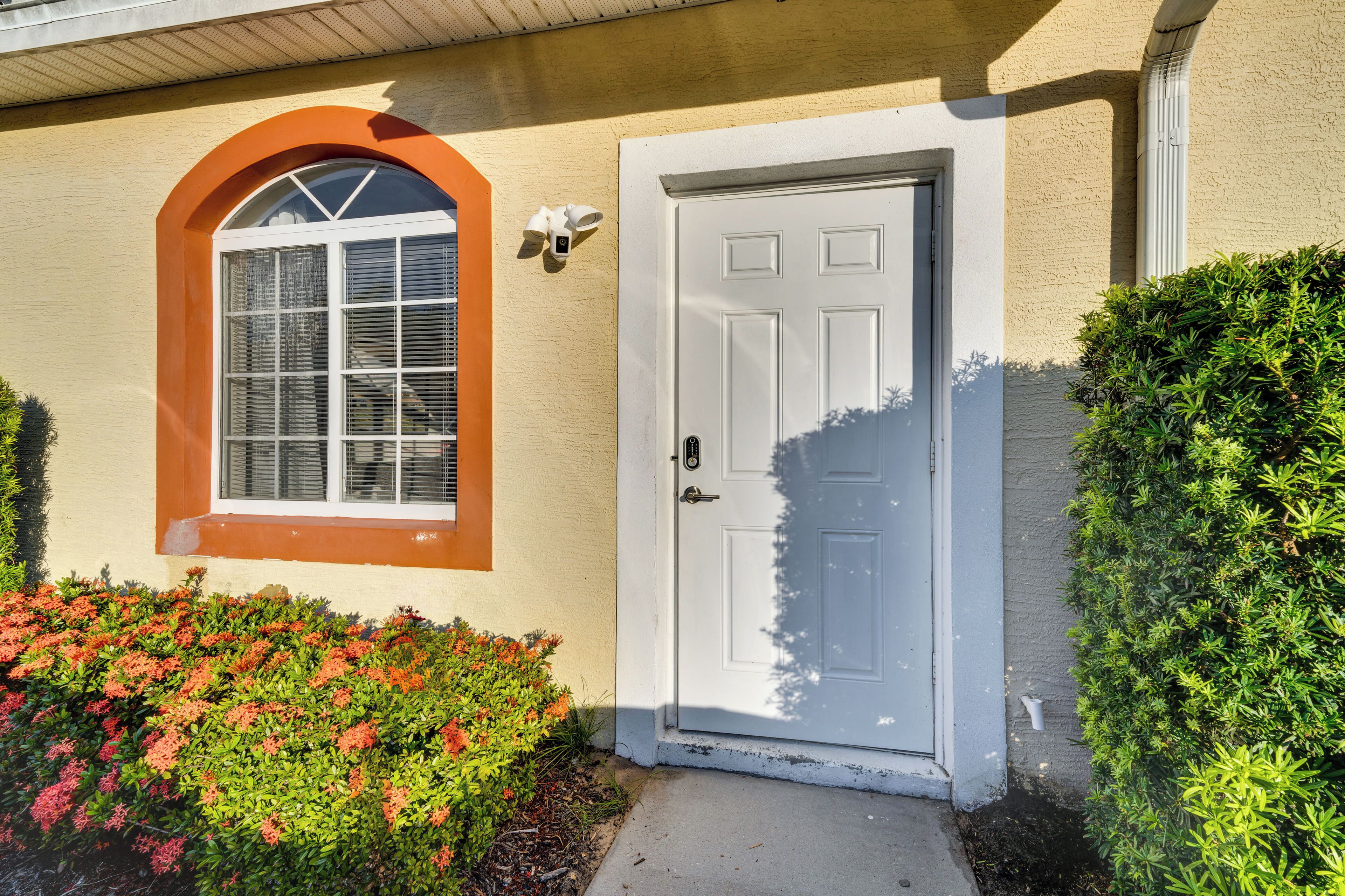 A house with a white door, a window with an arch, and a small porch area.