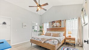 A bedroom with a wooden bed, a nightstand, a ceiling fan, and a door with a number 53 sign on the floor.