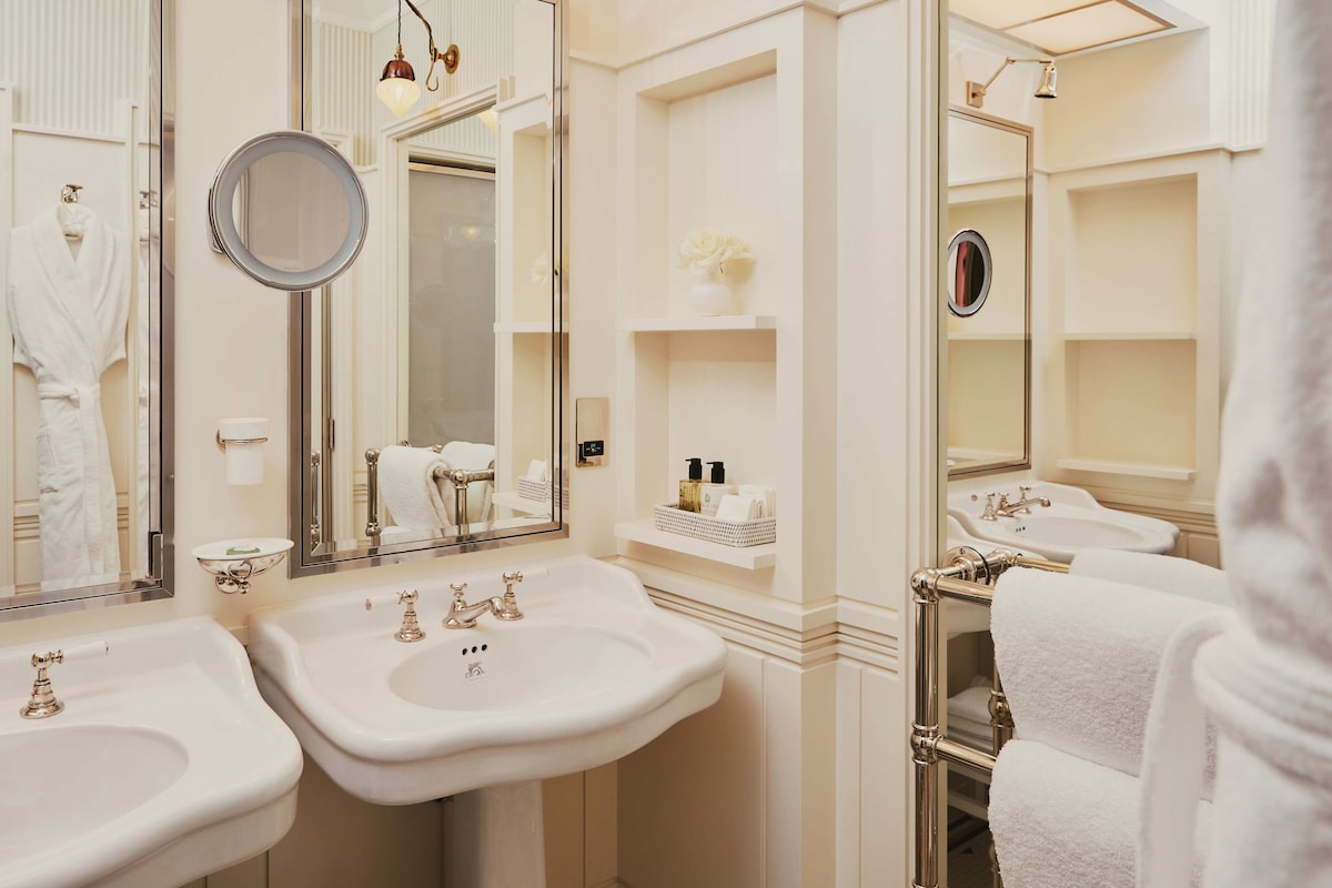 A bathroom with two sinks, a mirror, and a towel rack.