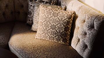 A corner of a room with a patterned sofa and multiple decorative pillows.