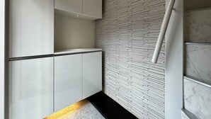 A modern kitchen with white cabinetry and a patterned backsplash. - NAOMI (Osaka)