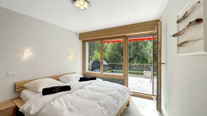 Un dormitorio con cama, ventana y vistas al exterior.