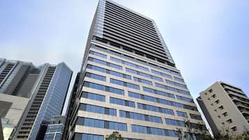 A tall, modern skyscraper with a grid of windows and a reflective glass facade.