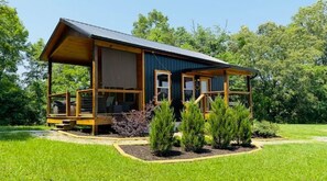 Eine Holzhütte mit Veranda, umgeben von einem gepflegten Garten.