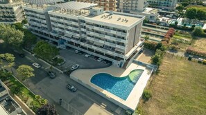 A multi-story building with a rooftop parking area and a swimming pool. - Adorable Flat With Large Terrace Overlooking the sea (San Michele al Tagliamento)