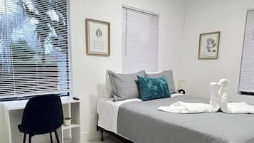 Quarto moderno com cama, escrivaninha e cadeira.